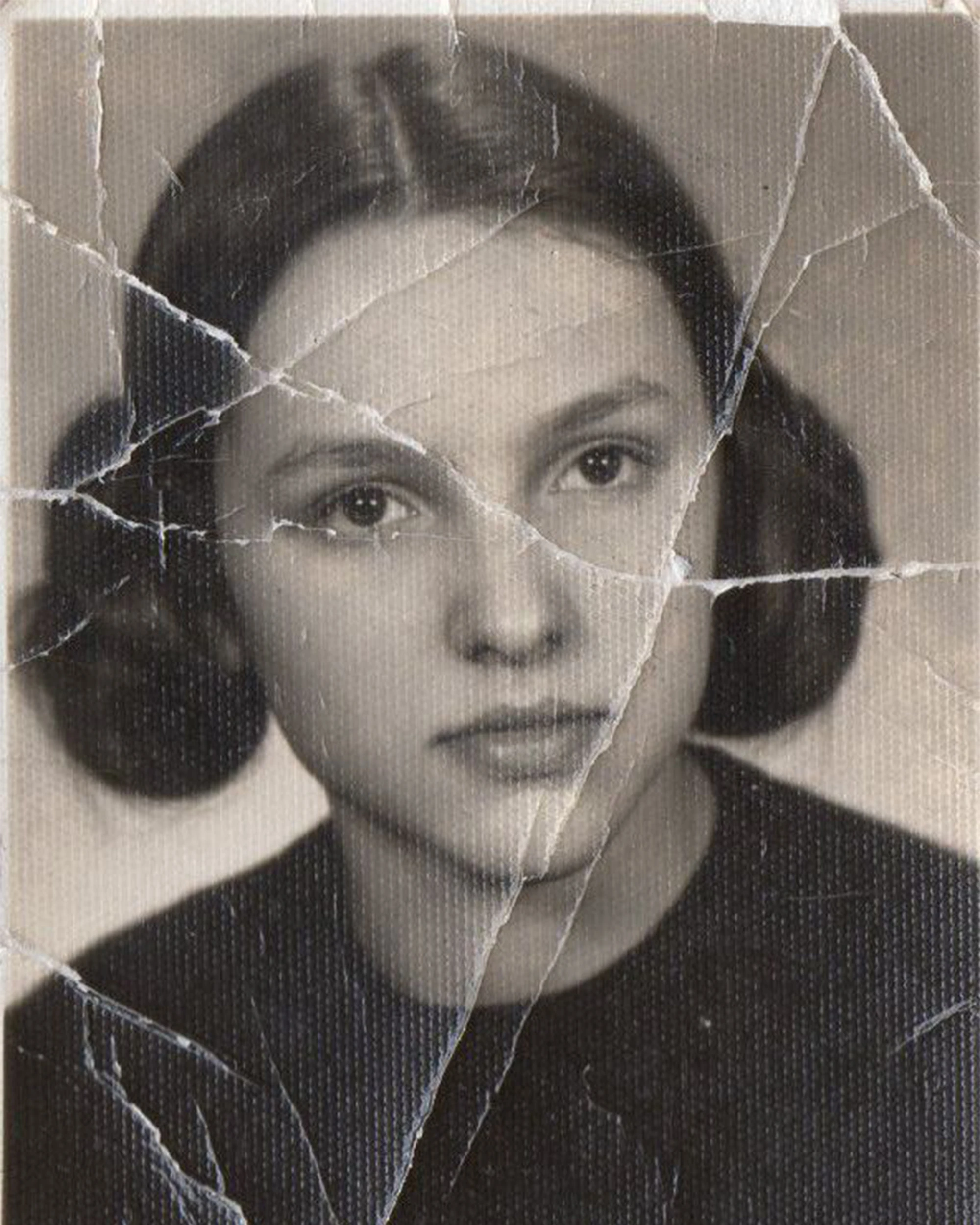 Cracked vintage portrait of a young woman before restoration