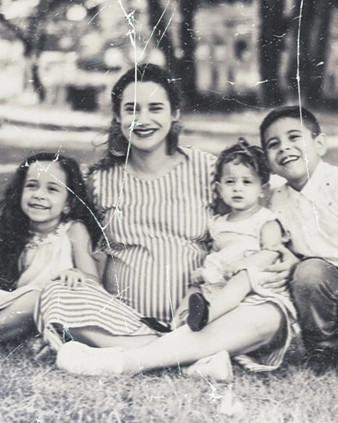 Cracked family photo of mother with children before repair