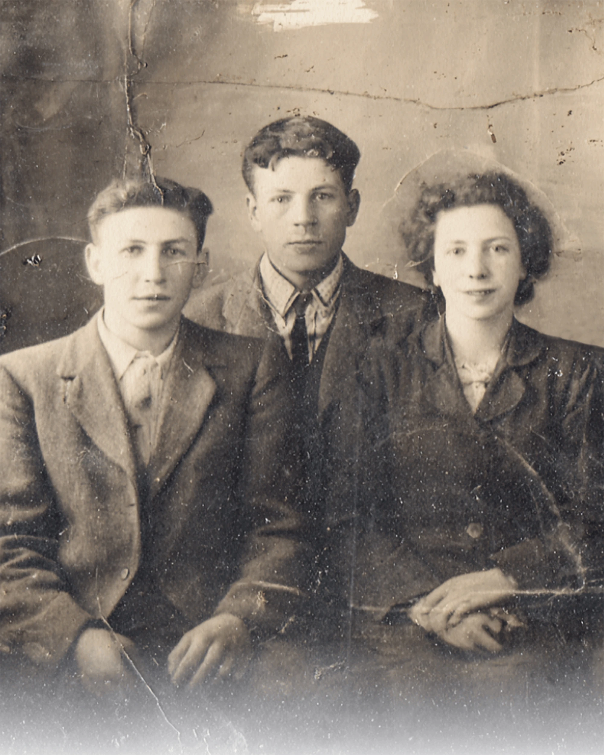 Aged sepia group portrait of three young people before restoration