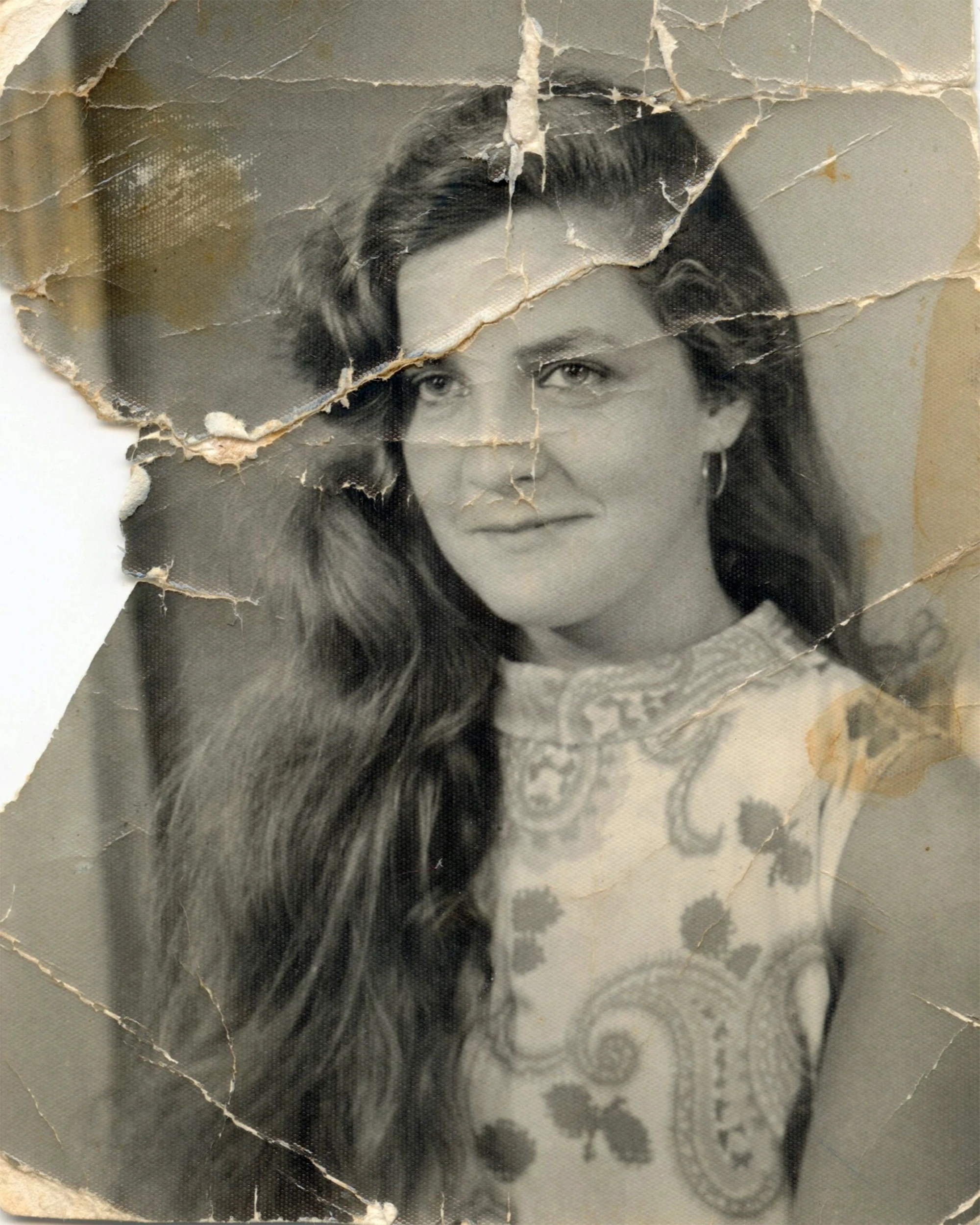 Severely cracked portrait of a woman before restoration